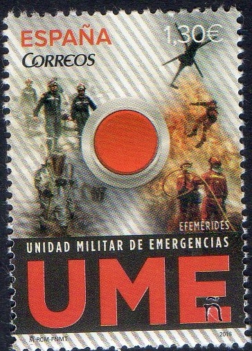 5032 -Efemérides. Boton rojo de emergencias sobre fondo de imágenesdel personal de la UME.