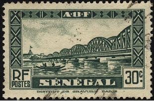 Puente de Faidherbe sobre el rio Senegal, y nativos en canoa.