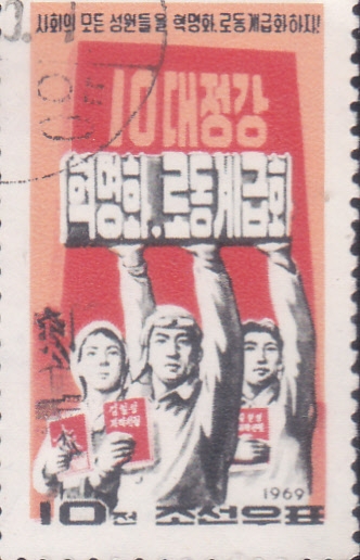 Tres coreanos con libros y carteles.